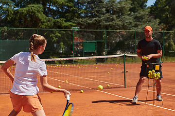 Image showing A professional tennis player and her coach training on a sunny day at the tennis court. Training and preparation of a professional tennis player