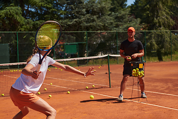 Image showing A professional tennis player and her coach training on a sunny day at the tennis court. Training and preparation of a professional tennis player