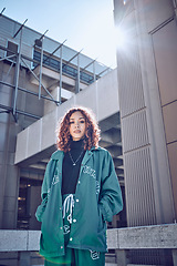 Image showing City, urban fashion and portrait of woman in streetwear with buildings and sun in background. Cool hip hop street style, girl from Puerto Rico with serious face and youth on outdoor summer weekend.