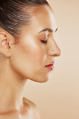 Image showing Face, beauty and skincare with a model woman profile posing in studio on a beige background for wellness. Cosmetics, wellness and natural with an attractive young female posing to promote a product