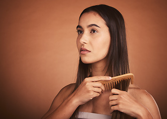 Image showing Beauty, hair and woman with comb in studio with luxury hair care for healthy and clean hairstyle. Health, wellness and grooming, beautiful model girl combing straight hair style on brown background.