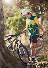Image showing Bike, nature and stretching with a man cyclist in the mountains for exercise, cardio or adventure. Fitness, sports and cycling with a male athlete warming up with his bicycle in the forest or woods