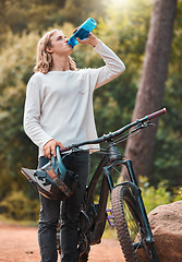 Image showing Drinking water, bike sport and man on an outdoor forest nature trail for exercise and sports. Bicycle training, cycling workout and fitness of an adventure athlete on a woods dirt road for wellness