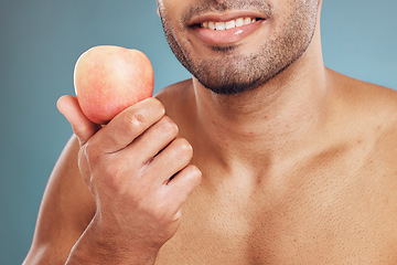 Image showing Hand, apple and beauty with a man model in studio on a blue background for heathy eating or diet. Food, fruit and health with a young male posing with a nutrition snack for natural care or vitamins