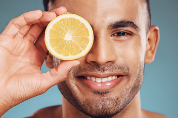 Image showing Skincare, lemon and man in face portrait in a studio for facial wellness, healthy glow or cosmetics advertising. Young beauty model smile with vitamin c fruit for dermatology product ingredient
