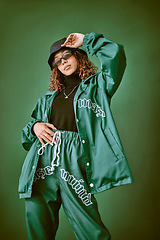 Image showing Fashion clothes, style and black woman with green rap, gen z or hip hop aesthetic outfit for cool, edgy or fashionable look. Designer brand apparel, attitude or teen fashion model on green background