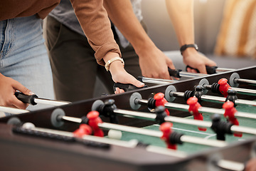 Image showing Hands, foosball and table with friends playing a game together indoors for fun or recreation. Football, fun and leisure with a friend group together to play at a party or celebration event