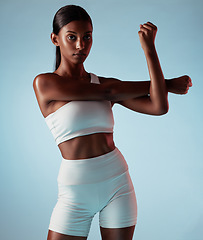 Image showing Fitness, body and stretching black woman in studio for exercise, workout or wellness lifestyle portrait with mock up advertising or marketing. Young sports woman with training fashion on blue mockup