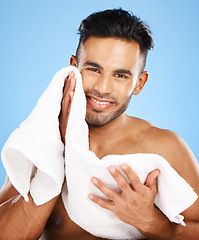 Image showing Towel, face and skincare of beauty man in studio for facial cleaning, healthy glow or cosmetics mock up advertising with portrait smile. Young model for men skin care wash routine on blue mockup