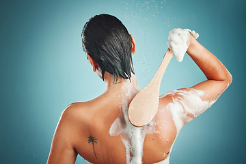 Image showing Skincare, back and woman in a shower for cleaning, hair and wellness against a blue background mockup. Beauty, brush and skin, scrub and exfoliate by girl model in a studio, relax and washing