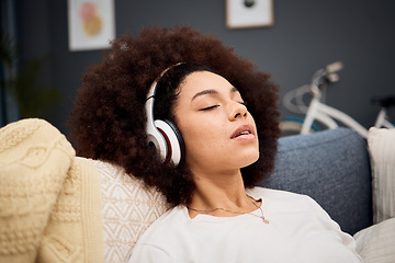 Image showing Music, relax and black woman on a sofa listening to radio, streaming or wellness podcast in a living room. Headphones, woman and rest on a couch with online audio track, meditation and playlist