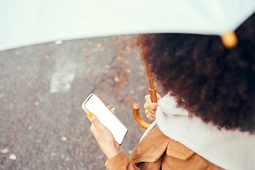 Image showing Phone, woman with umbrella and blank screen for marketing, advertising or product placement in city streets. Young black girl, smartphone for social media and outside in autumn with mobile tech