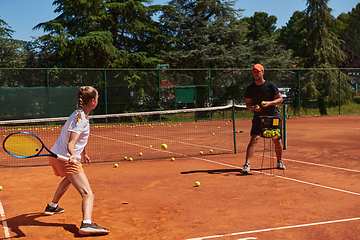 Image showing A professional tennis player and her coach training on a sunny day at the tennis court. Training and preparation of a professional tennis player