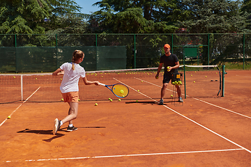 Image showing A professional tennis player and her coach training on a sunny day at the tennis court. Training and preparation of a professional tennis player