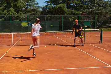 Image showing A professional tennis player and her coach training on a sunny day at the tennis court. Training and preparation of a professional tennis player