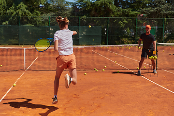 Image showing A professional tennis player and her coach training on a sunny day at the tennis court. Training and preparation of a professional tennis player