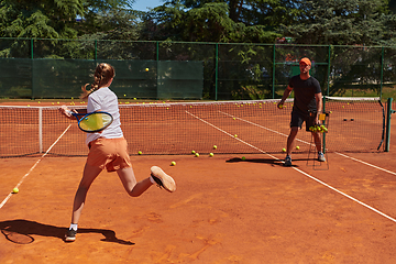 Image showing A professional tennis player and her coach training on a sunny day at the tennis court. Training and preparation of a professional tennis player