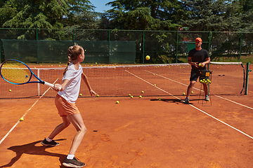 Image showing A professional tennis player and her coach training on a sunny day at the tennis court. Training and preparation of a professional tennis player