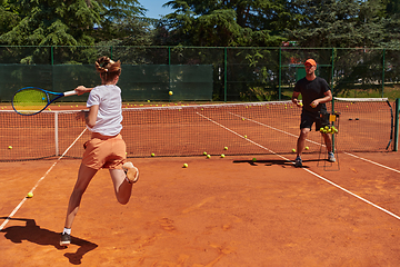 Image showing A professional tennis player and her coach training on a sunny day at the tennis court. Training and preparation of a professional tennis player