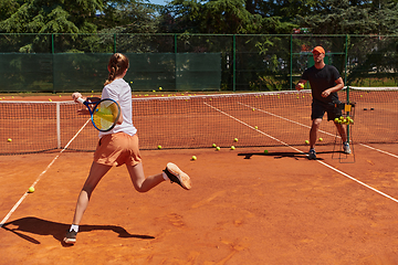 Image showing A professional tennis player and her coach training on a sunny day at the tennis court. Training and preparation of a professional tennis player