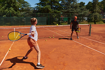 Image showing A professional tennis player and her coach training on a sunny day at the tennis court. Training and preparation of a professional tennis player