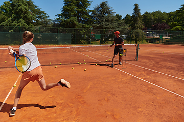 Image showing A professional tennis player and her coach training on a sunny day at the tennis court. Training and preparation of a professional tennis player