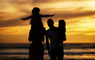 Image showing Beach, sunset and silhouette of family on vacation, holiday or trip outdoors. Love, care and shadow, outline or profile of man, woman and kids enjoying quality time together or bonding by seashore.