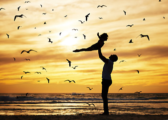 Image showing Father, flying child and beach silhouette of seaside travel holiday with birds in sunset background. Strong dad, happy kid playing and vacation trip fun together with ocean waves, sand and summer sun