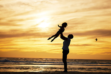 Image showing Sunset, silhouette and father with child at the beach with love and care on summer vacation. Playful, freedom and man playing with his kid in nature by ocean or sea on holiday, adventure or journey.