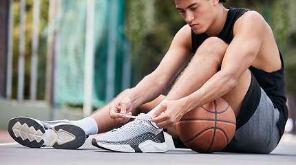 Image showing Basketball player, shoes and sports in preparation for game, match or fitness on the court outdoors. Man on basketball court tying shoe laces getting ready or prepare for exercise or training workout