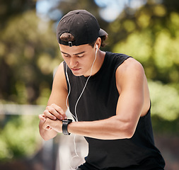 Image showing Watch, man and check fitness with music for cardio exercise training in nature park. Audio motivation lifestyle, sports workout and person monitor running speed on digital tech smartwatch outdoors