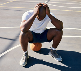 Image showing Basketball, sports and depressed man on court with hands on head after loss, fail and bad game. Fitness, sadness and upset black man sitting on ball on outdoor basketball court, frustrated and mad