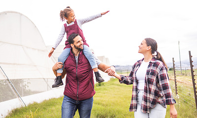 Image showing Family, farm and parents carrying child walking, bonding and explore countryside together. Farming, agriculture and girl on shoulder of dad going to check vegetables, crops and produce in greenhouse