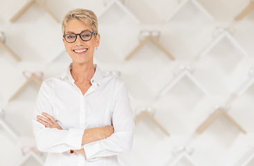 Image showing Portrait, glasses and vision with a woman optometrist standing arms crossed alone in her optometry store. Ophthalmology, eyewear and frame with a mature female optician selling frame lenses