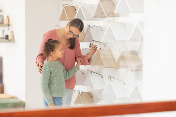 Image showing Mother, daughter and buying glasses for optometry and vision in a retail store. Family, opthalmology and health care with a little girl and her parent shopping for eyewear or optical equipment