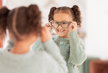 Image showing Children, mirror and girl with glasses at optometry store, testing or shopping for new eyewear. Vision, choice and happy kid trying spectacles or lenses at optics shop while looking at reflection.