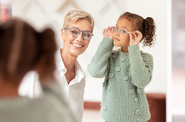 Image showing Eyes, consulting and glasses by girl and optometrist woman at optician store for choice, fitting and eye test. Eyesight, eyeglasses and ophthalmologist and child consultation, eye care and vision