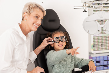 Image showing Child, eye exam and ocular health with ophthalmologist doing vision test for glasses during consultation. Happy girl with eye care optometry specialist woman helping patient for wellness and health
