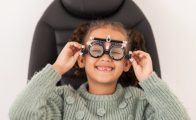 Image showing Vision, eye exam and girl with trial lens for prescription spectacles at optometry shop. Eyewear, eyesight test and happy child trying new optical lenses for optic health, wellness and care in clinic