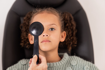 Image showing Optometry, eye care and girl getting a vision test with a occluder in a medical optical clinic. Checkup, optometrist and child from Brazil doing a eye exam with a optic tool for healthy eyesight.