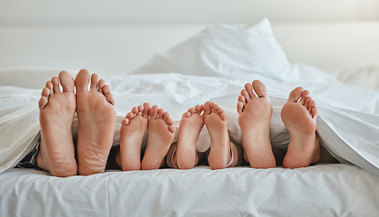 Image showing Morning, feet and family sleeping in bedroom for weekend, holiday or nap leisure in house. Relax, mother and dad with young children resting in bed with blanket in family home together.