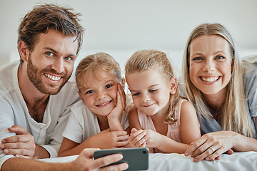 Image showing Family, phone and bed with a girl, sister and parents bonding together in the bedroom of the home in the morning. Children, portrait and mobile with a man, woman and daughter siblings lying on a bed