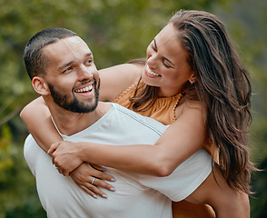 Image showing Piggy back, couple and happy hug of a man and woman in nature with love, care and happiness. People with a smile and play together smiling about romantic anniversary and loving relationship outdoor