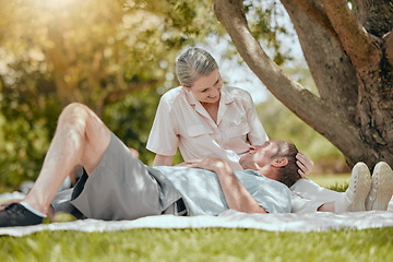 Image showing Love, happy and elderly couple relax on picnic, bond and rest in a park, having fun on a date. Lovers, retirement and senior man and woman sharing romance, happy and smile against forest tree