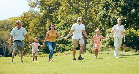 Image showing Grandparents, parents and kids walking in the park, happy .and bonding together outdoor. Family, holding hands and fun being loving, happiness and adventure on vacation, spend quality time and love.