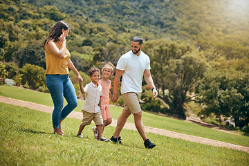 Image showing Park, family and nature walking of a mother, dad and kids outdoor in the sun on a hike. Happy mom, father and kids walk on a field with parents spending quality time together with a smile on grass