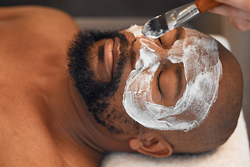 Image showing Facial, skincare and relax with black man in spa for beauty, luxury and mud mask. Wellness, therapy and health with male and beautician brush cosmetics product on face for peace, massage and salon