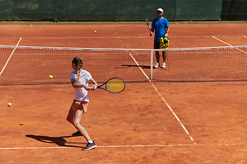 Image showing A professional tennis player and her coach training on a sunny day at the tennis court. Training and preparation of a professional tennis player