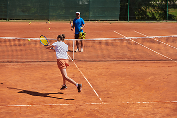 Image showing A professional tennis player and her coach training on a sunny day at the tennis court. Training and preparation of a professional tennis player