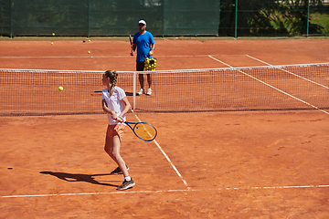 Image showing A professional tennis player and her coach training on a sunny day at the tennis court. Training and preparation of a professional tennis player